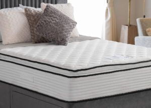 Apley Bale 1000 Encapsulated Pillowtop Mattress with plush pillowtop finish and edge-to-edge support, displayed in a bedroom with stylish, textured pillows.