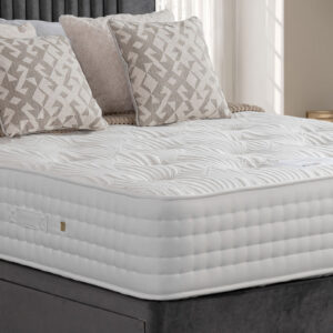 Apley Cashmere Ortho 2000 Pocket Sprung Mattress on a grey bed frame, decorated with beige patterned and cream pillows.