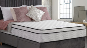 Apley Pacino 1000 Pocket Sprung Encapsulated Memory Hybrid Pillow Top Mattress on a bed with grey and pink decorative pillows.