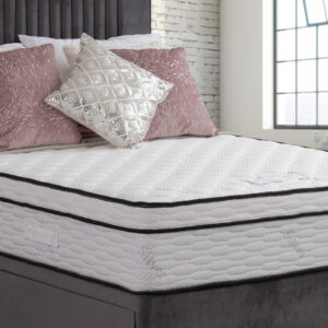 Apley Pacino 1000 Pocket Sprung Encapsulated Memory Hybrid Pillow Top Mattress on a bed with grey and pink decorative pillows.