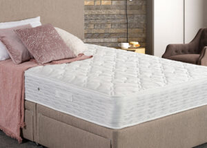 Image of Remy mattress on a divan bedframe with pillows and soft furnishings. The mattress shows its luxury quilted finish.