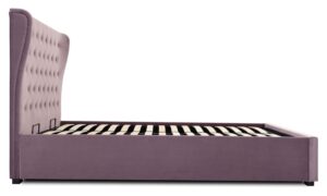 This image shows a king-size Kensington Ottoman Bed Velvet from Apleybeds.co.uk. The bed is upholstered in a luxurious soft heather velvet and has a softly winged headboard with Chesterfield-style button tufting. The black block feet add a touch of sophistication. The end-opening ottoman lifts on easy-glide gas strut mechanisms to reveal a spacious storage compartment.