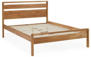This image shows a wooden bed in a light wood finish with a mid-century modern design. The bed has a simple headboard and footboard with rounded edges. The bed is also equipped with a slatted base.