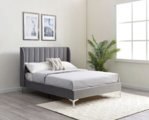 This image shows a king-size Avery bed from Apleybeds.co.uk. The bed is made of solid wood and has a classic and timeless design. The headboard is tall and has a curved top. The bed is upholstered in a luxurious grey velvet fabric.