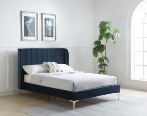 This image shows a king-size Avery bed from Apleybeds.co.uk. The bed is made of solid wood and has a classic and timeless design. The headboard is tall and has a curved top. The bed is upholstered in a luxurious blue ink velvet fabric.