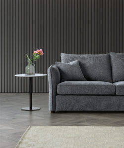 Full view of the Rubin Corner Sofa in Charcoal Bouclé in a modern setting with a side table and floral decor.