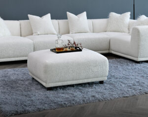 The Aluxo Lottie Modular Corner Sofa's ottoman in a modern living room setup