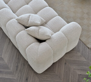 op-down view of the Tribeca Corner Sofa in oatmeal Bouclé fabric, adorned with matching cushions