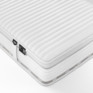 Close-up of a Jay-Be TRUECORE mattress showing a quilted white fabric surface with grey accents, and visible labels detailing the mattress features including e-Pocket and TrueCore technologies.