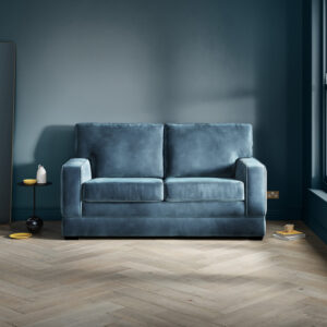 Urban 2 Seater Sofa Bed in a sophisticated blue fabric, in a modern living room setting.