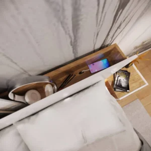 Close-up of the Dentro Bed’s headboard shelf, storing books, a smartphone, and decorative items.