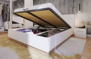 Dentro Ottoman Bed with the gas-lift storage feature raised, showing suitcases and bedding stored neatly underneath.