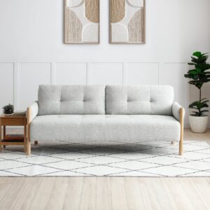 Front view of the Quinn Sofabed in natural bouclé fabric with wooden frame, styled in a modern living room.