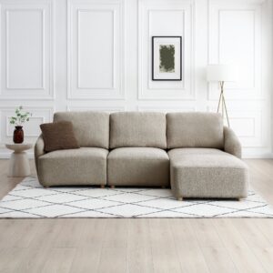 Como 3 Seater Modular Sofa in taupe boucle fabric with chaise, deep cushioned seats, and a sleek contemporary style on a patterned rug in a bright living room.
