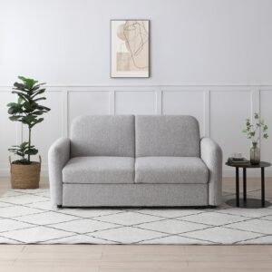 Light grey Cloud Click Clack Sofa Bed in boucle fabric, set in a modern living room with a side table and potted plant.