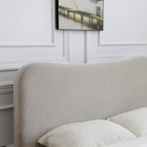 Curved upholstered headboard of the Mollie bed in a natural Scandi-style bedroom