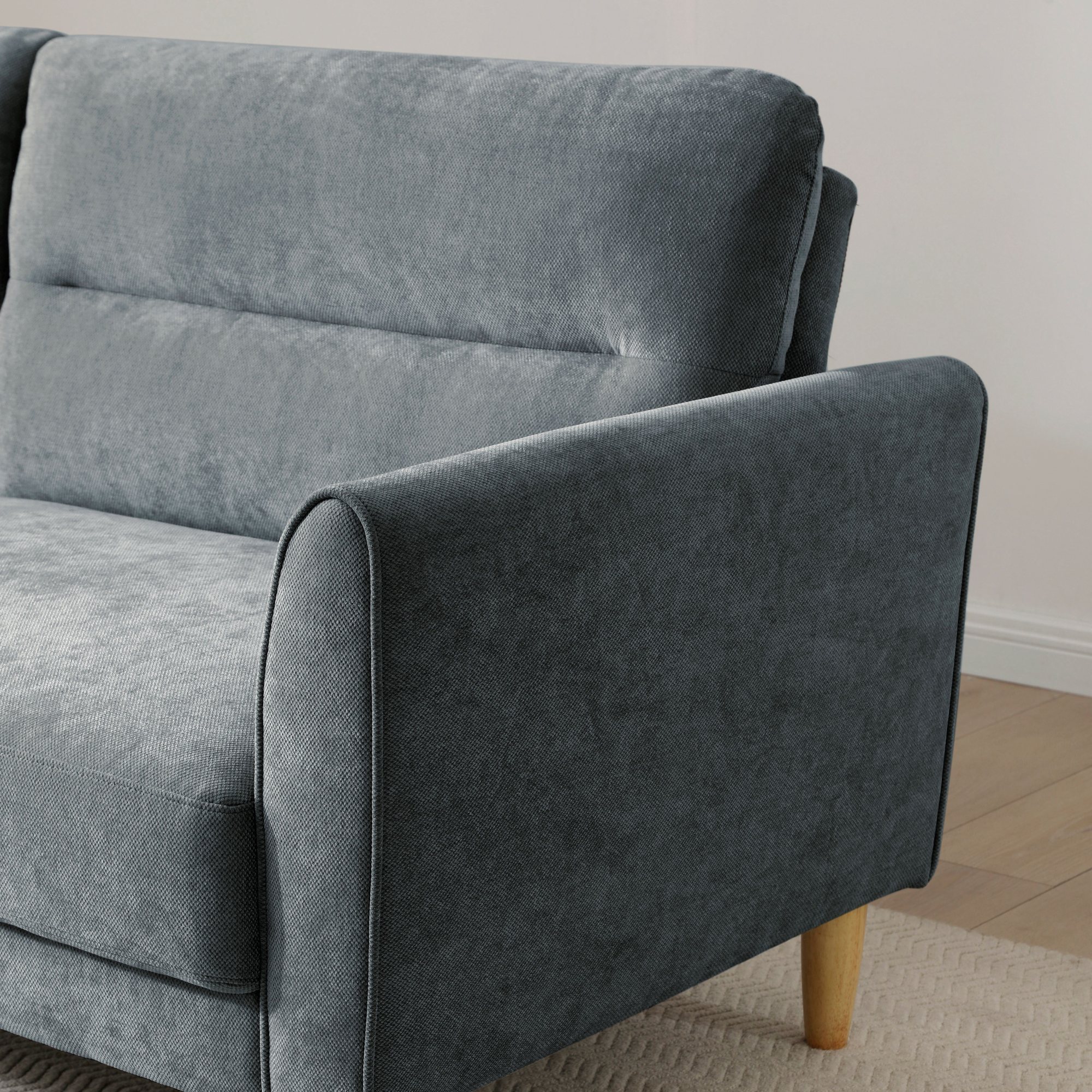 Close-up of the arm, chenille weave and wooden leg on the Harvey Sofa Bed in denim