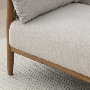 Close-up of the cane rattan arm panel and wooden frame on the Zara Sofa Bed
