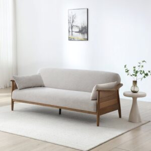 Zara rattan sofa bed with natural cane arms and a solid wood frame in a living room