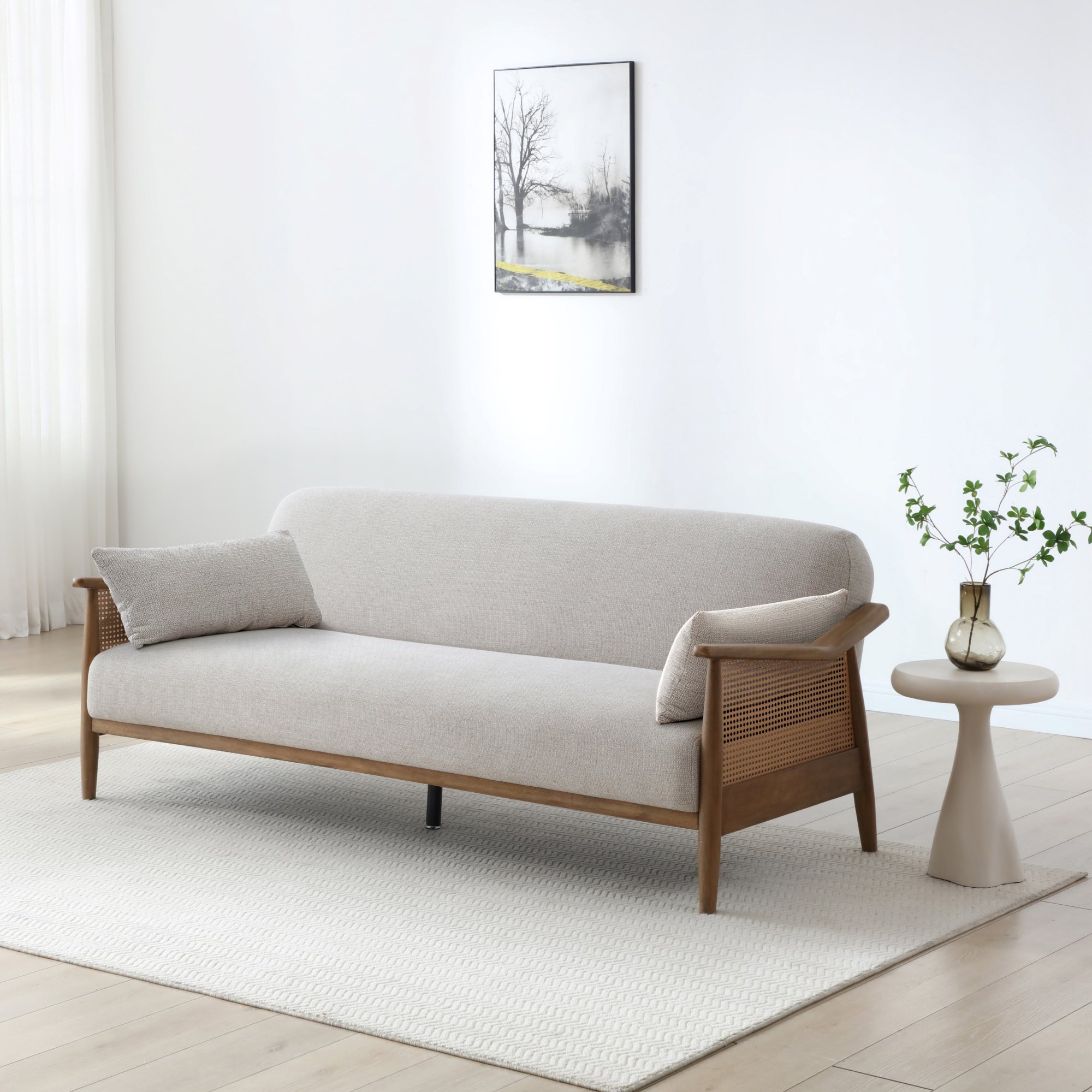 Zara rattan sofa bed with natural cane arms and a solid wood frame in a living room