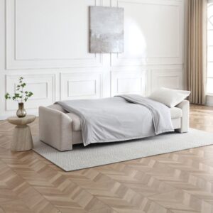 Evelyn Sofa Bed made up as a bed with bedding in a living room
