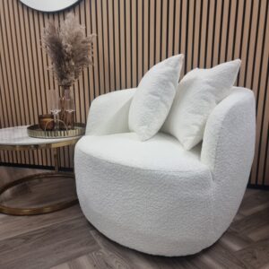 Cuddle cream boucle accent chair styled in a room with slatted wood panelling and a side table