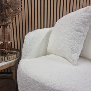 Close view of the Cuddle chair curved arm rolling into the seat in cream boucle