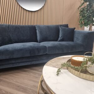 Lenox aegean blue velvet sofa in a showroom setting with a round marble coffee table