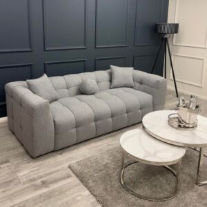 Aluxo Bubble grey boucle three seater sofa styled in a living room with a panelled wall, rug and coffee table