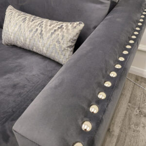 Close view of the Lincoln corner sofa velvet upholstery and chrome studs
