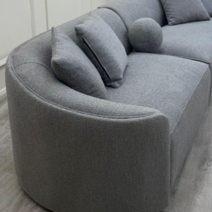 Close view of the Pebble sofa curved end, bolster cushions and looped grey boucle texture