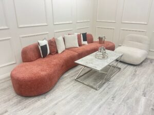 Close view of the Miami curved sofa in blush boucle showing the low deep seat and rounded end