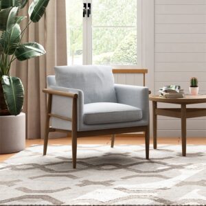 Alfie Scandi armchair in grey linen-mix on a washed oak ash frame beside a window and side table in a living room