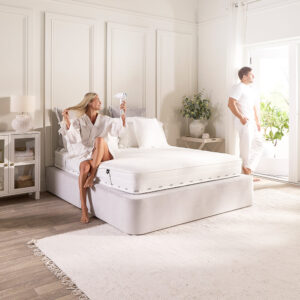 Couple getting ready in a bright bedroom with the Jay-Be Pure Anti-Allergy sprung mattress on a divan
