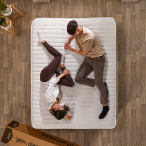Overhead view of a couple lying on the Jay-Be Ryze 800 mattress next to its delivery box