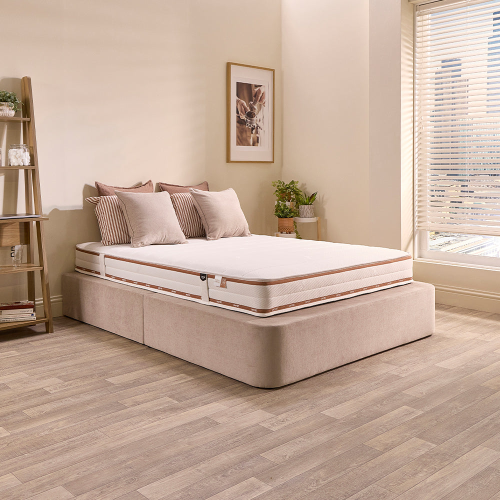 Jay-Be Ryze Deep Quilted mattress on a beige upholstered bed base in a bright bedroom with striped cushions