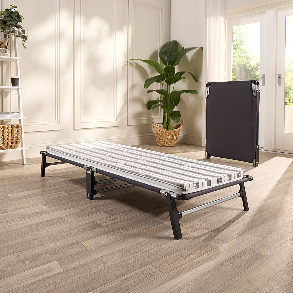 Jay-Be ME70 Mobile single folding guest bed opened with its striped mattress in a bright spare room