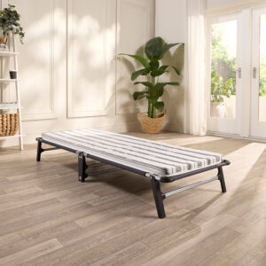 Jay-Be ME70 Mobile folding guest bed set up on a wooden floor beside a window