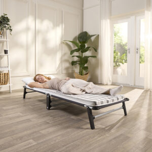 Guest resting on the Jay-Be ME70 Mobile single folding bed in a living room